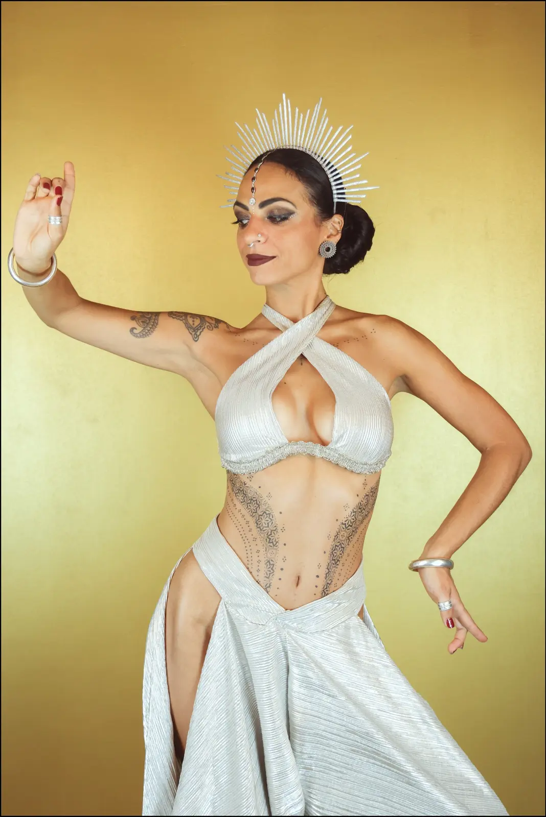 Leli Neeraja in bianco, in posa davanti a uno sfondo oro